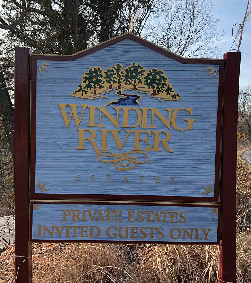 A sign for winding river estates says private estates invited guests only