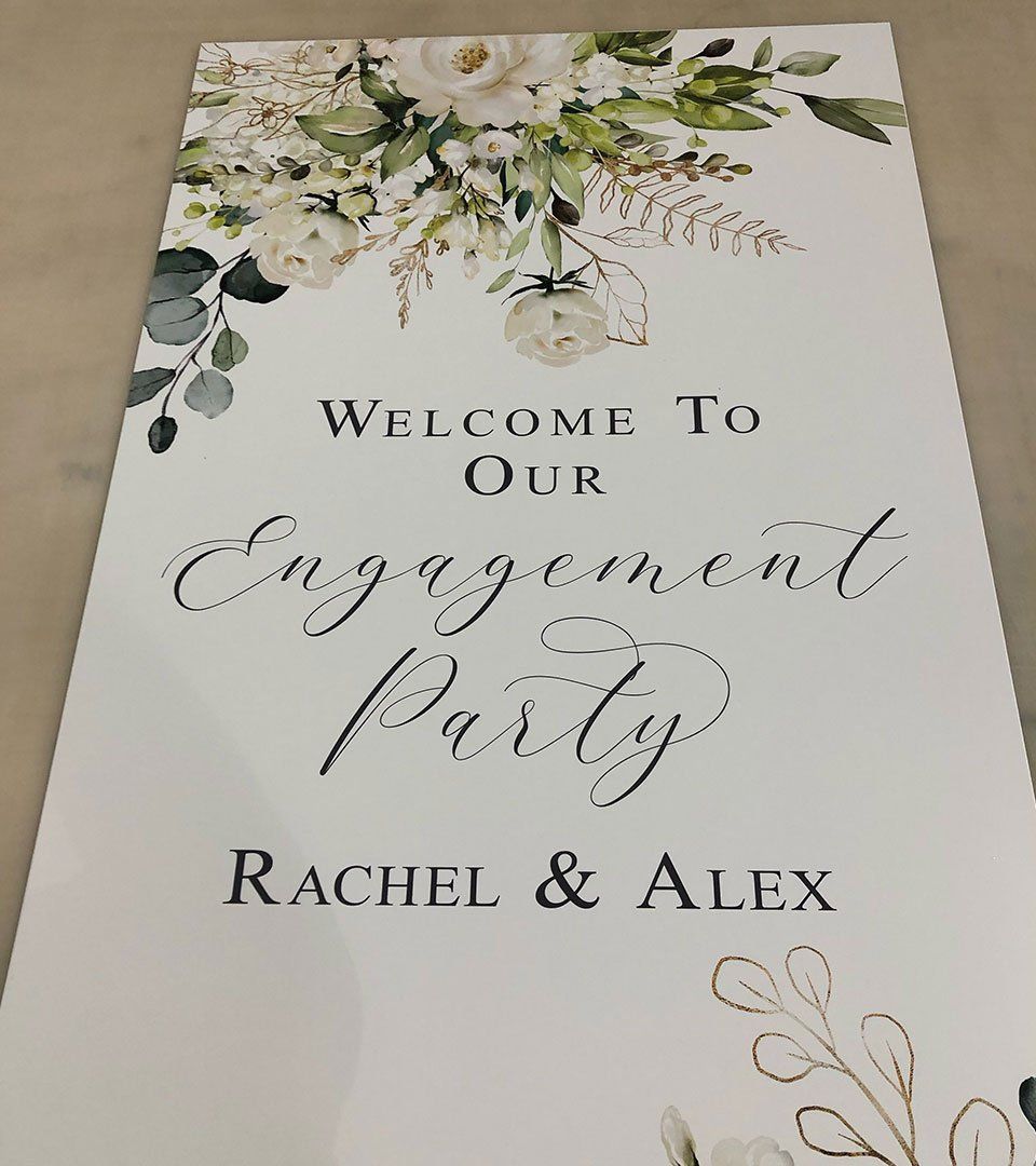 A welcome to our engagement party sign with flowers and leaves