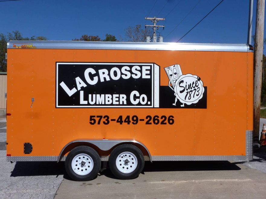 An orange trailer that says lacrosse lumber co. on it