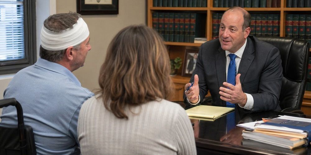 Scott Goldstein Workers Compensation and Disability Lawyer for New York State in his office with two clients.