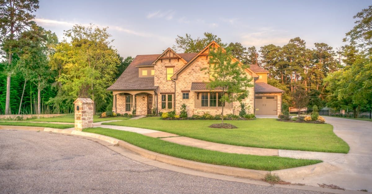 A large house is sitting on top of a lush green lawn in a residential neighborhood.