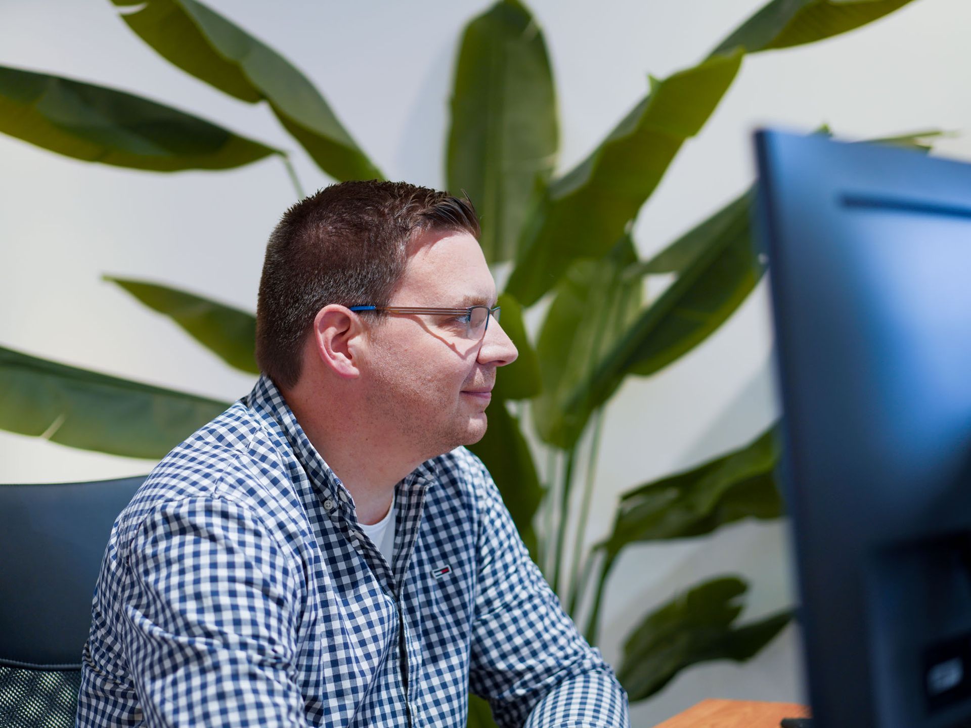 Ein Mann mit Brille sitzt vor einem Computermonitor.