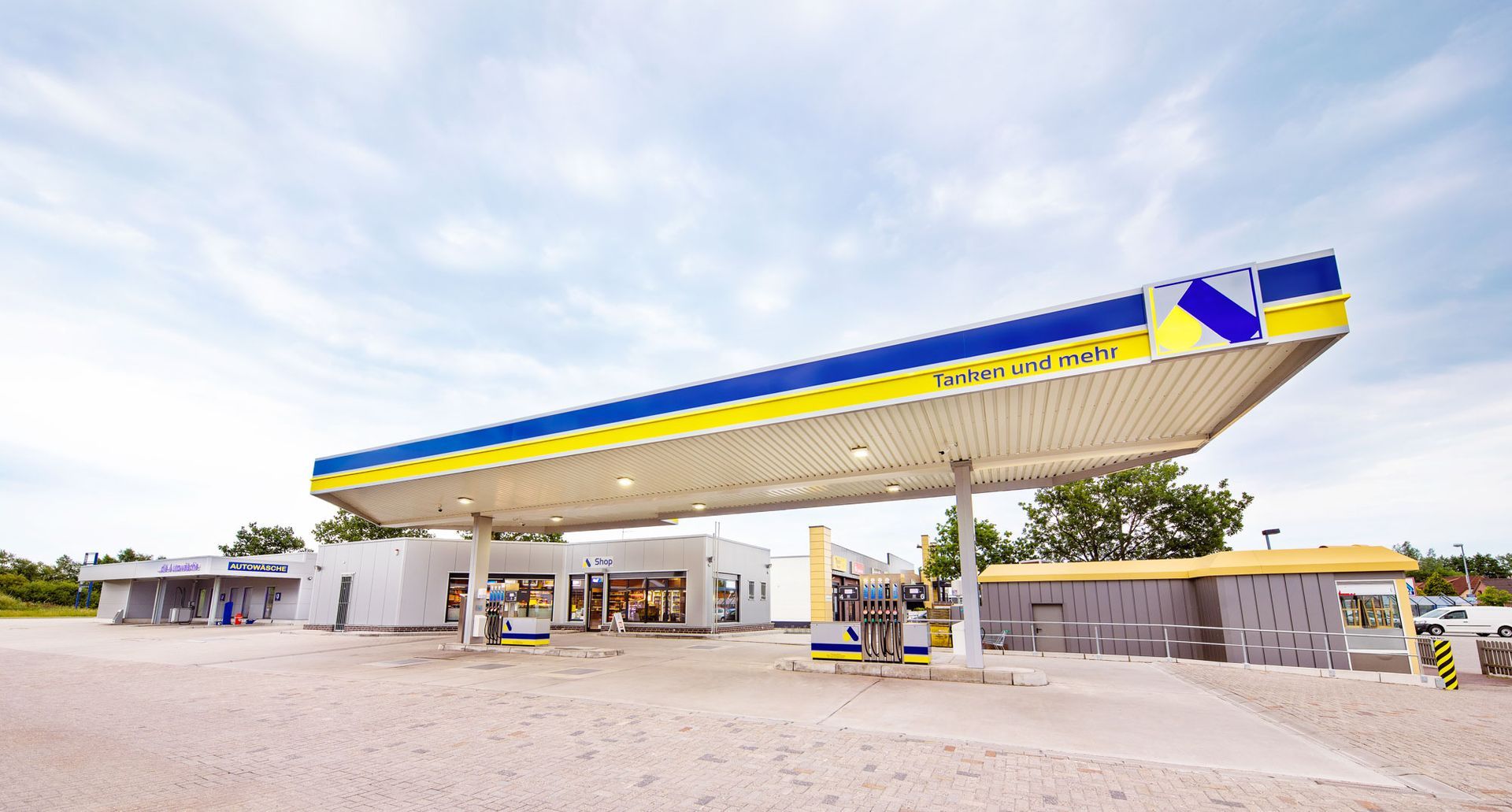 Eine Tankstelle mit einem blau-gelb gestreiften Dach