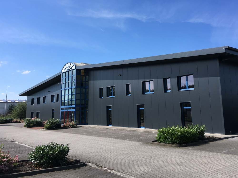 A large building with a lot of windows and a blue sky in the background.