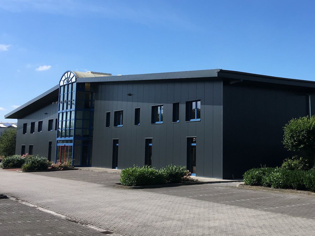 Ein großes Gebäude mit vielen Fenstern und einem blauen Himmel im Hintergrund