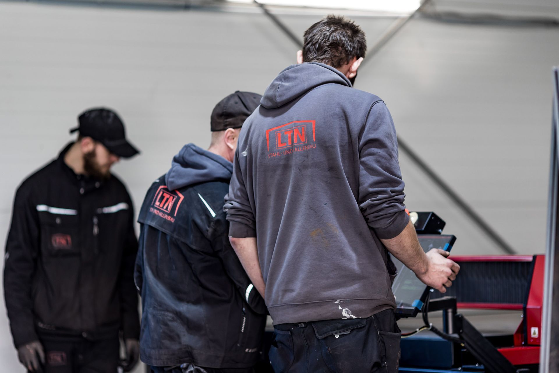 A group of men are working on a machine in a garage.