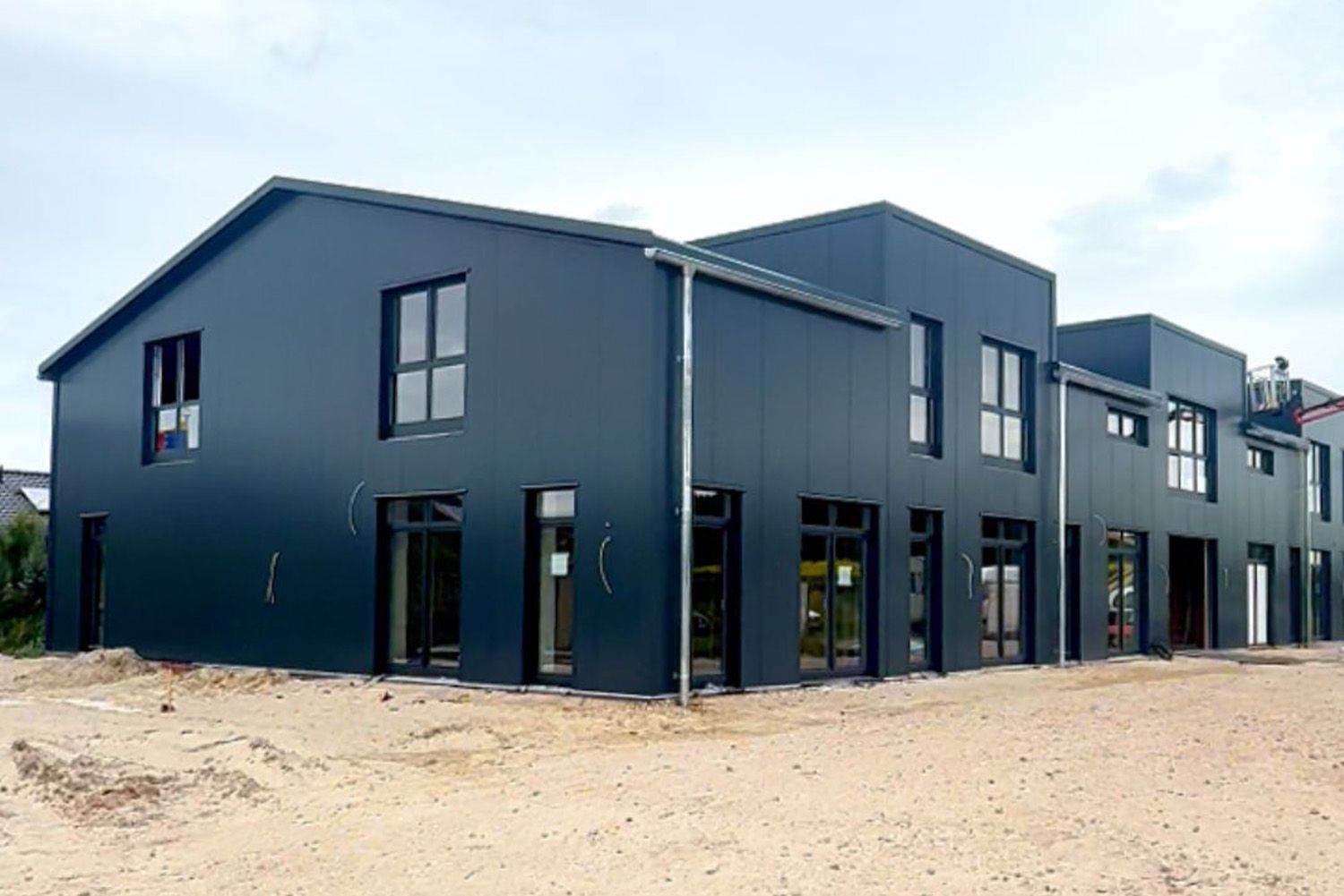 A large black building with a lot of windows is being built.