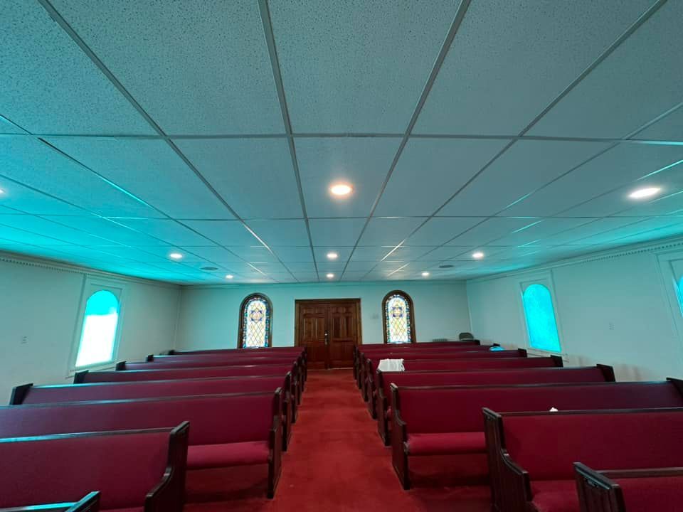 A church with red benches and a white ceiling.