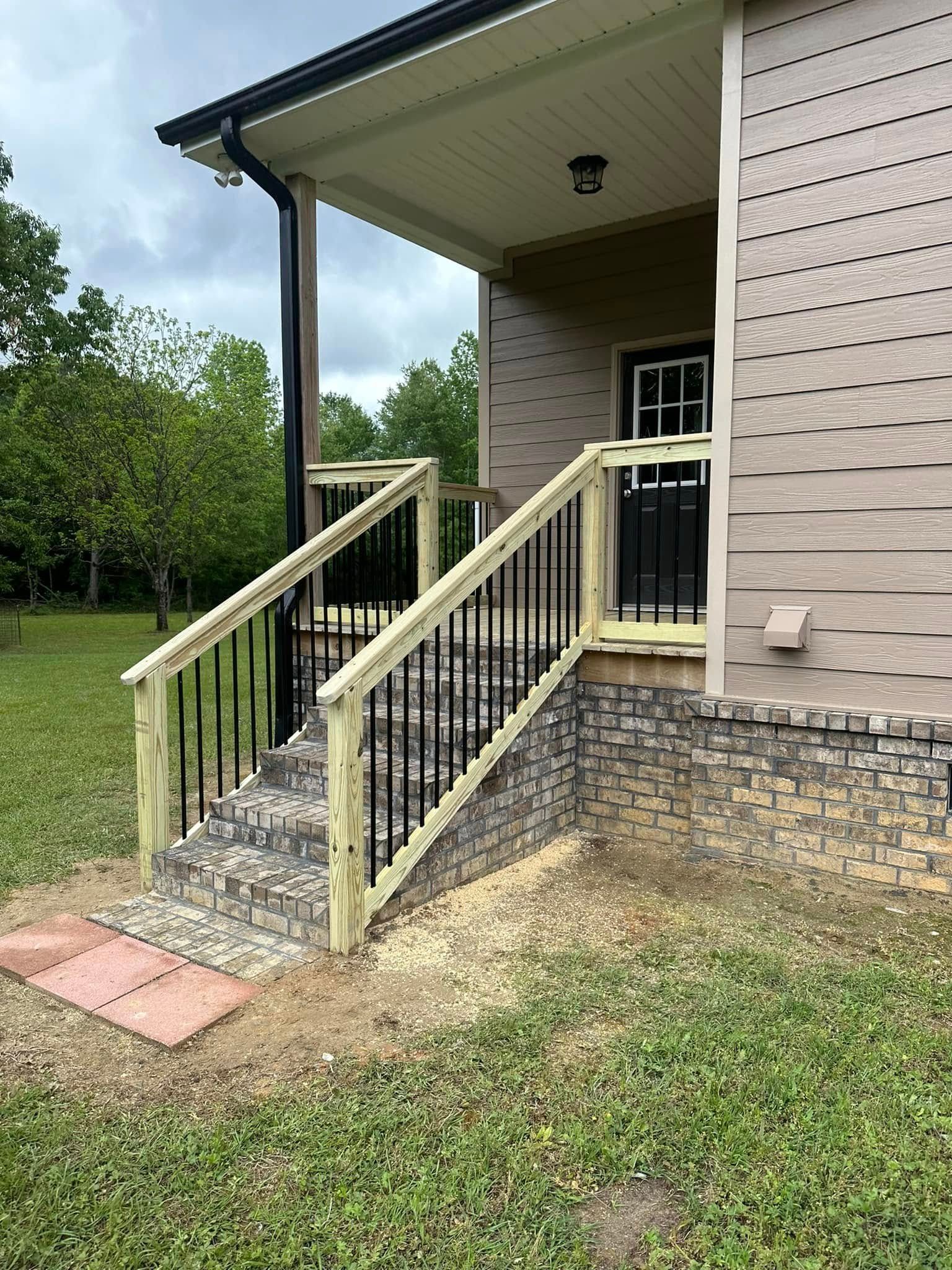 A house with stairs leading up to the front door and a wooden railing.