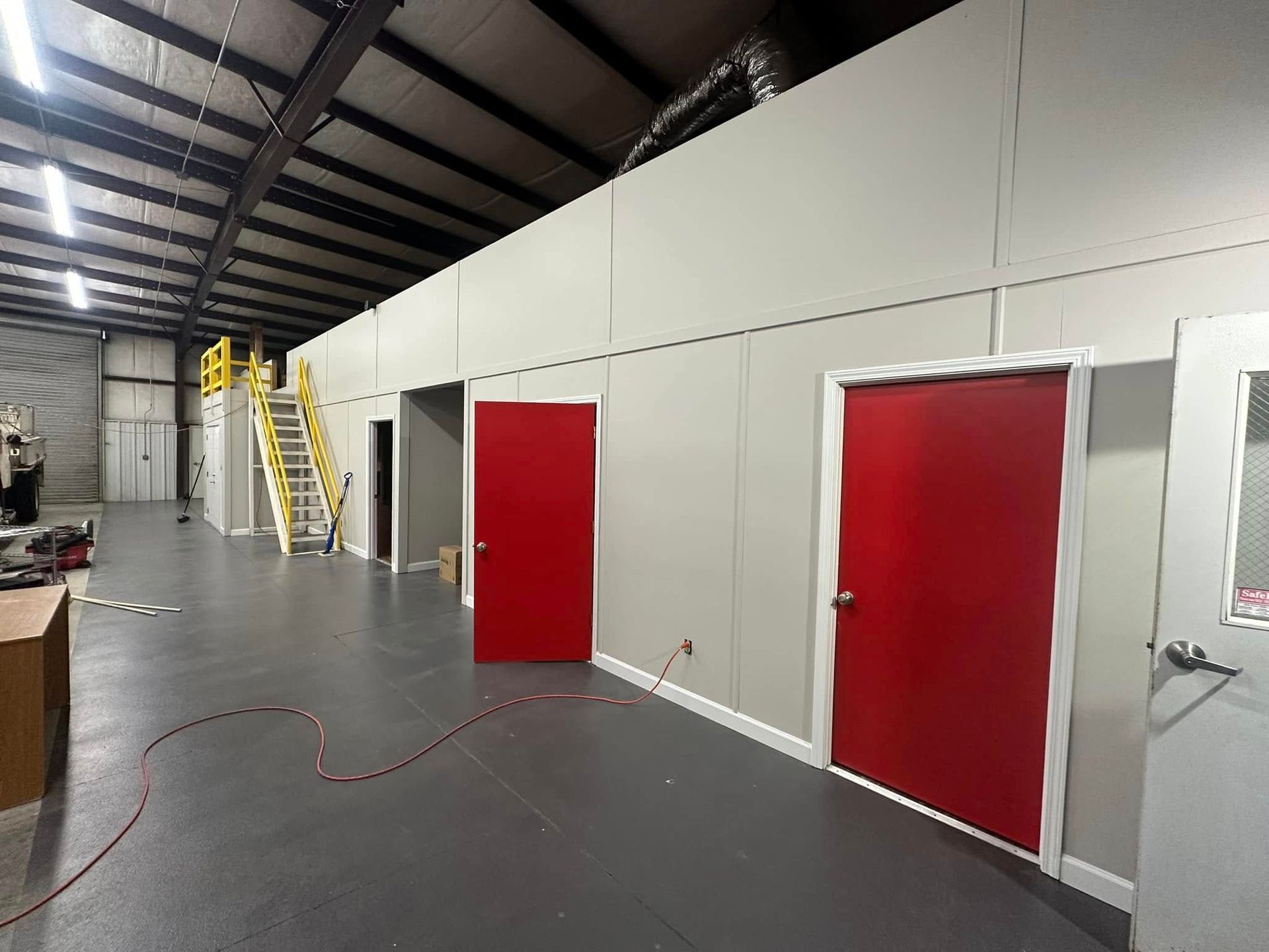 A warehouse with red doors and white walls