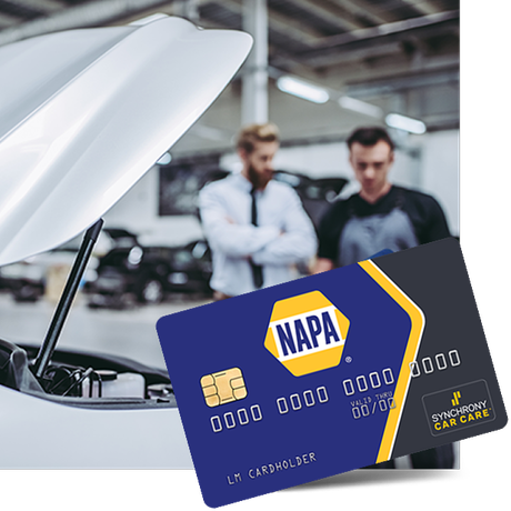 Blue NAPA battery in car engine bay, with two mechanics blurred in the background | Tinley Auto Repair & Towing Inc