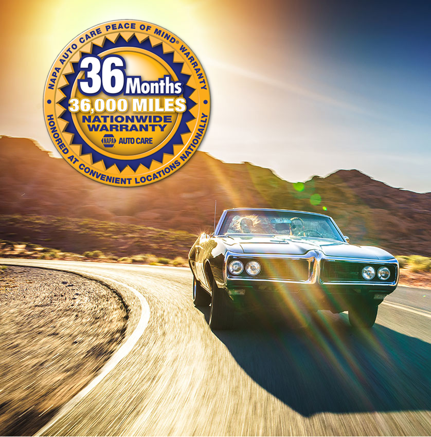 Classic convertible driving on a winding desert road at sunset, with a 36-month warranty badge. | Tinley Auto Repair & Towing Inc