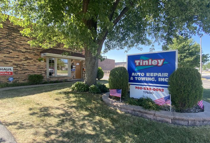 Tinley Auto Repair sign in front of a brick building on a sunny day | Tinley Auto Repair & Towing Inc