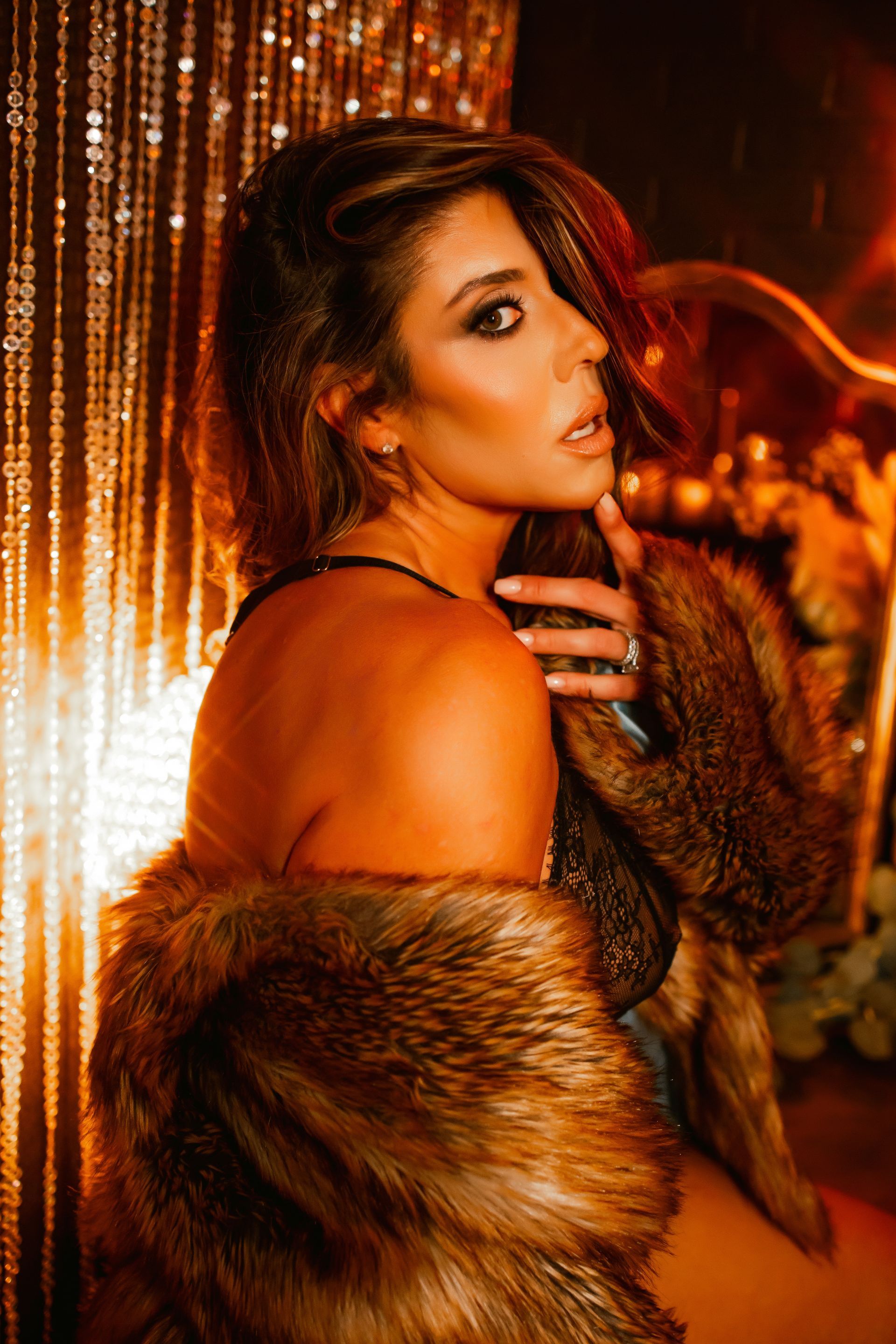 A woman in a fur coat is sitting in front of a mirror.