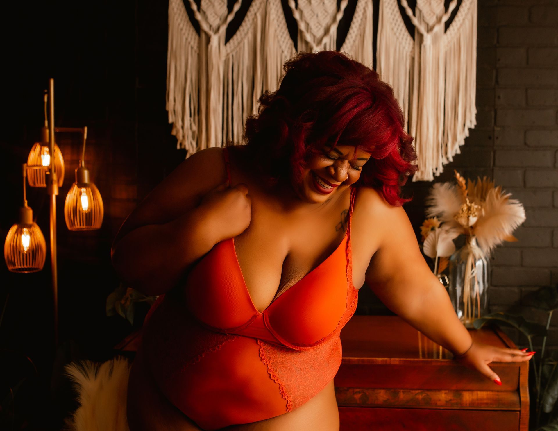 A woman in lingerie is standing in a dark room.