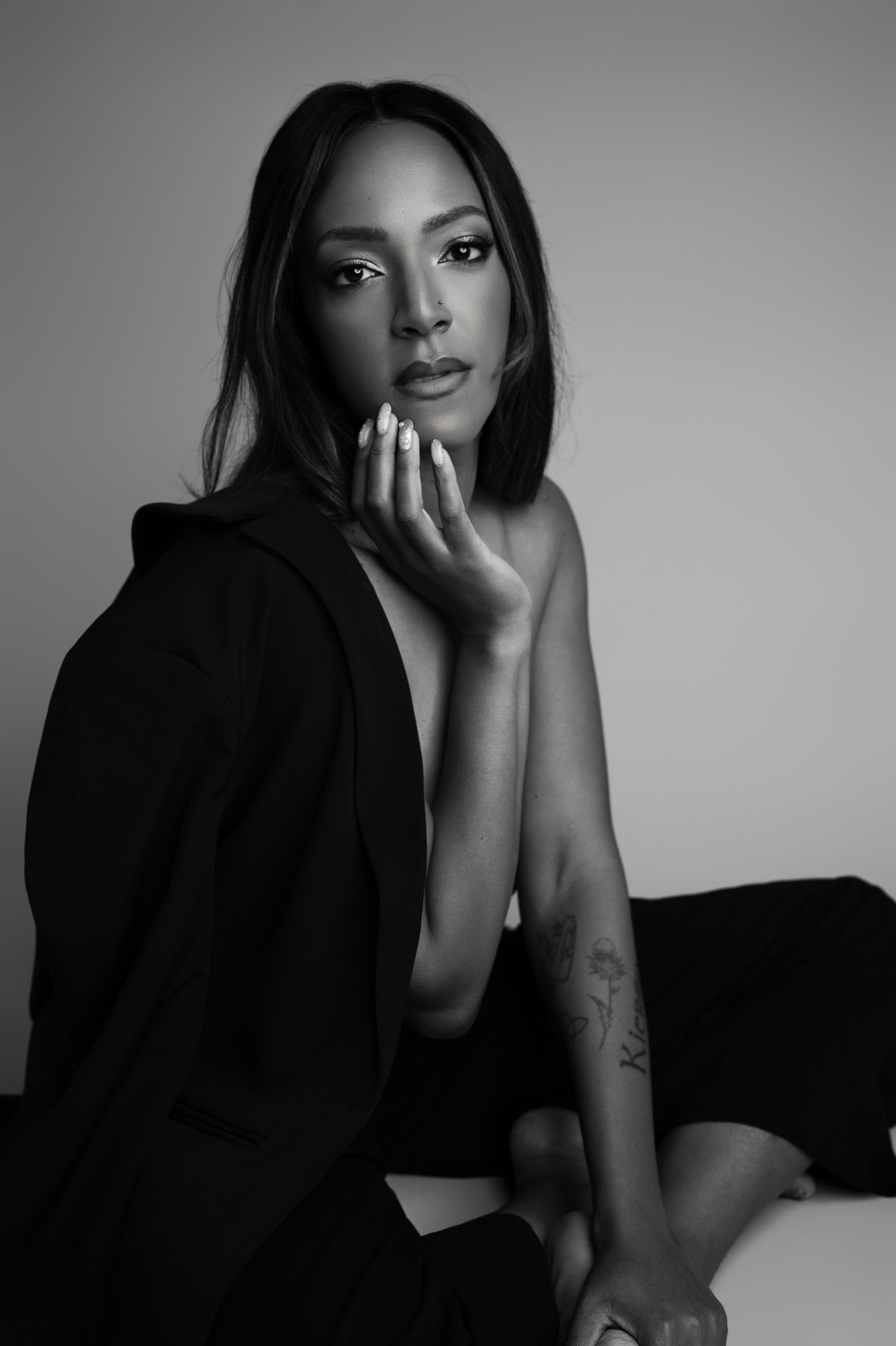 A woman with long curly hair is wearing a green dress and smiling.