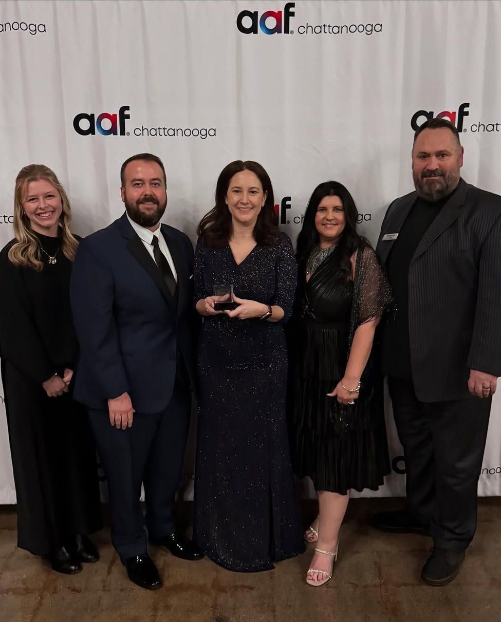 A group of people are posing for a picture in front of a wall with the word aaf on it.