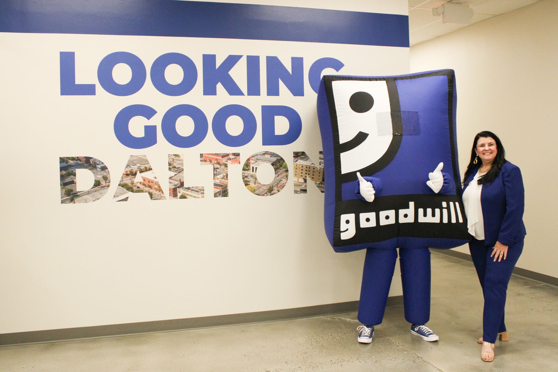 Two people are standing in front of a wall that says looking good dalton