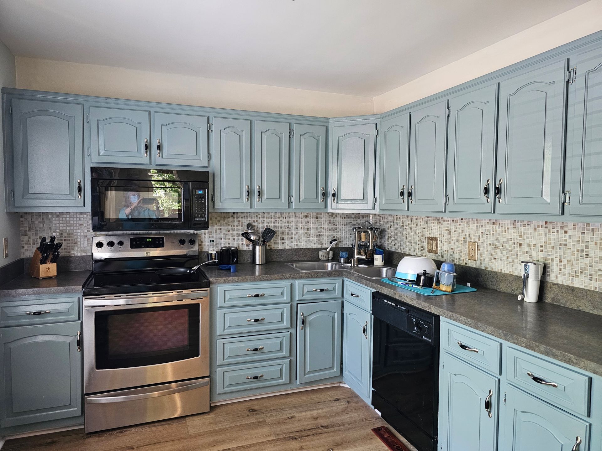 Kitchen with blue cabinets, stainless steel appliances, and gray countertops.