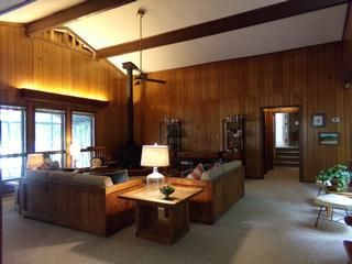 Living room with wood paneling, sofas, and a fireplace.