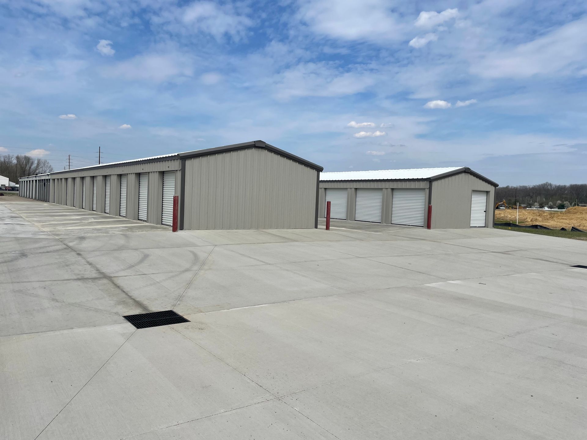 A row of storage units are lined up in a parking lot.