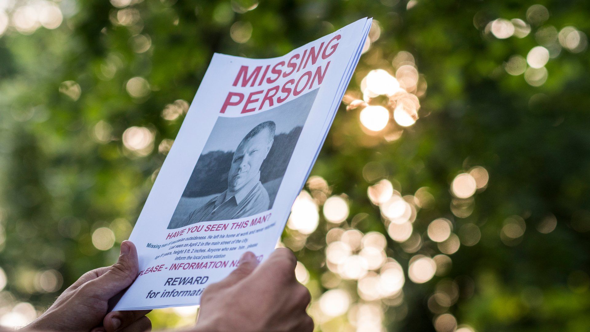 Man holding a flyer with the announcement of the missing man