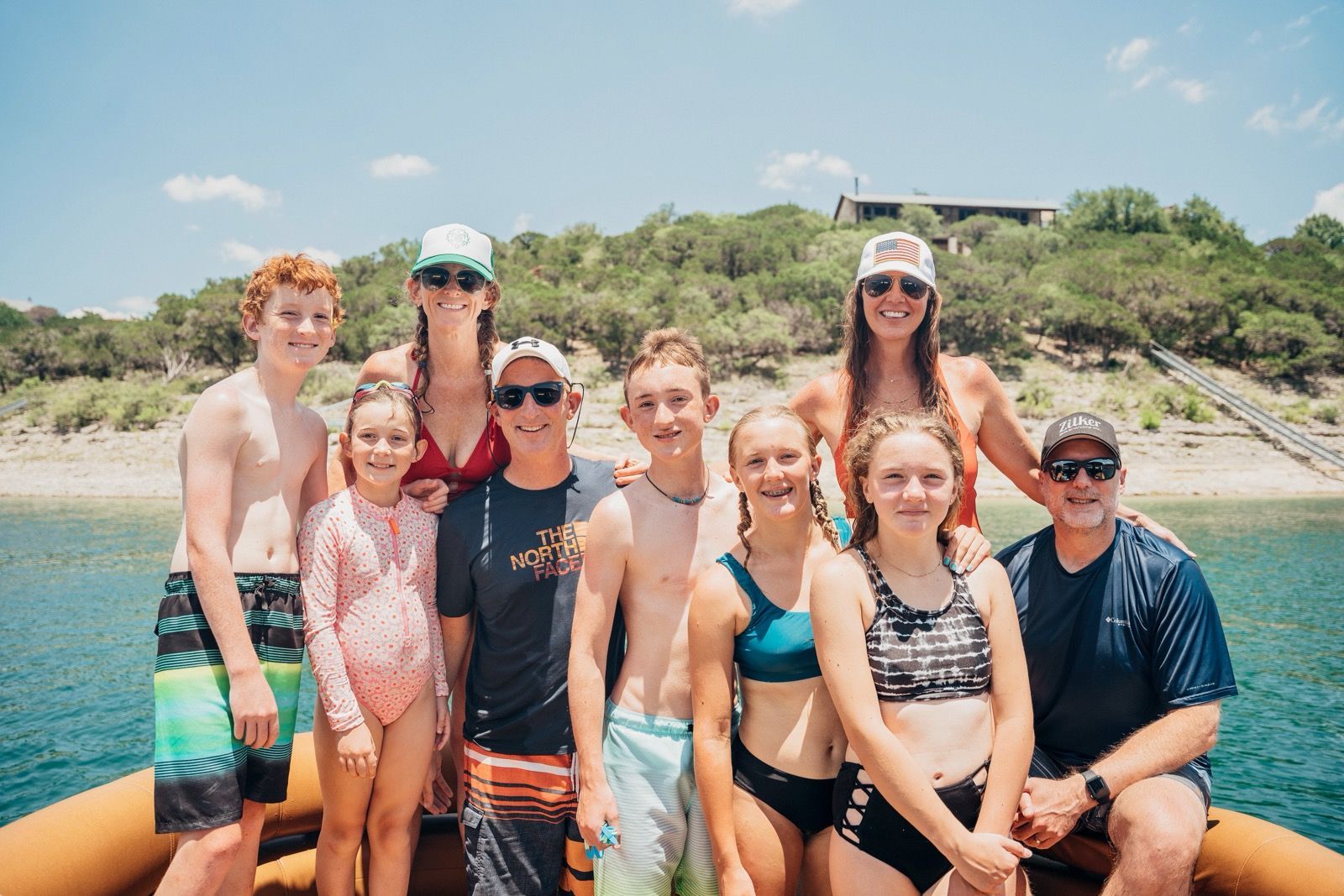 A family is posing for a picture on a boat in the water.