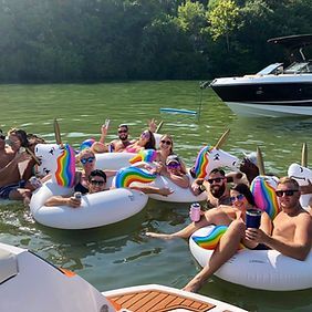 A group of people are floating on unicorn floats in the water.