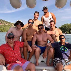A group of men are posing for a picture on a boat.