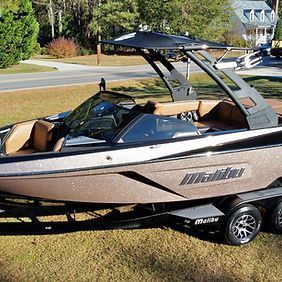 A boat is parked on the grass next to a road.