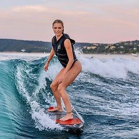 A woman is riding a wave on a surfboard in the ocean.