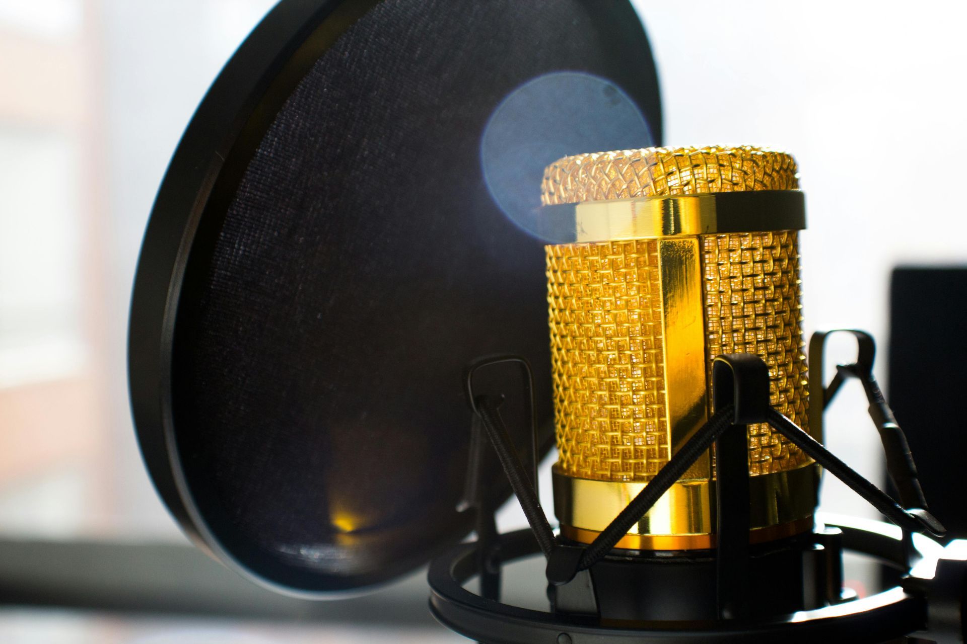 A close up of a gold microphone with a black filter