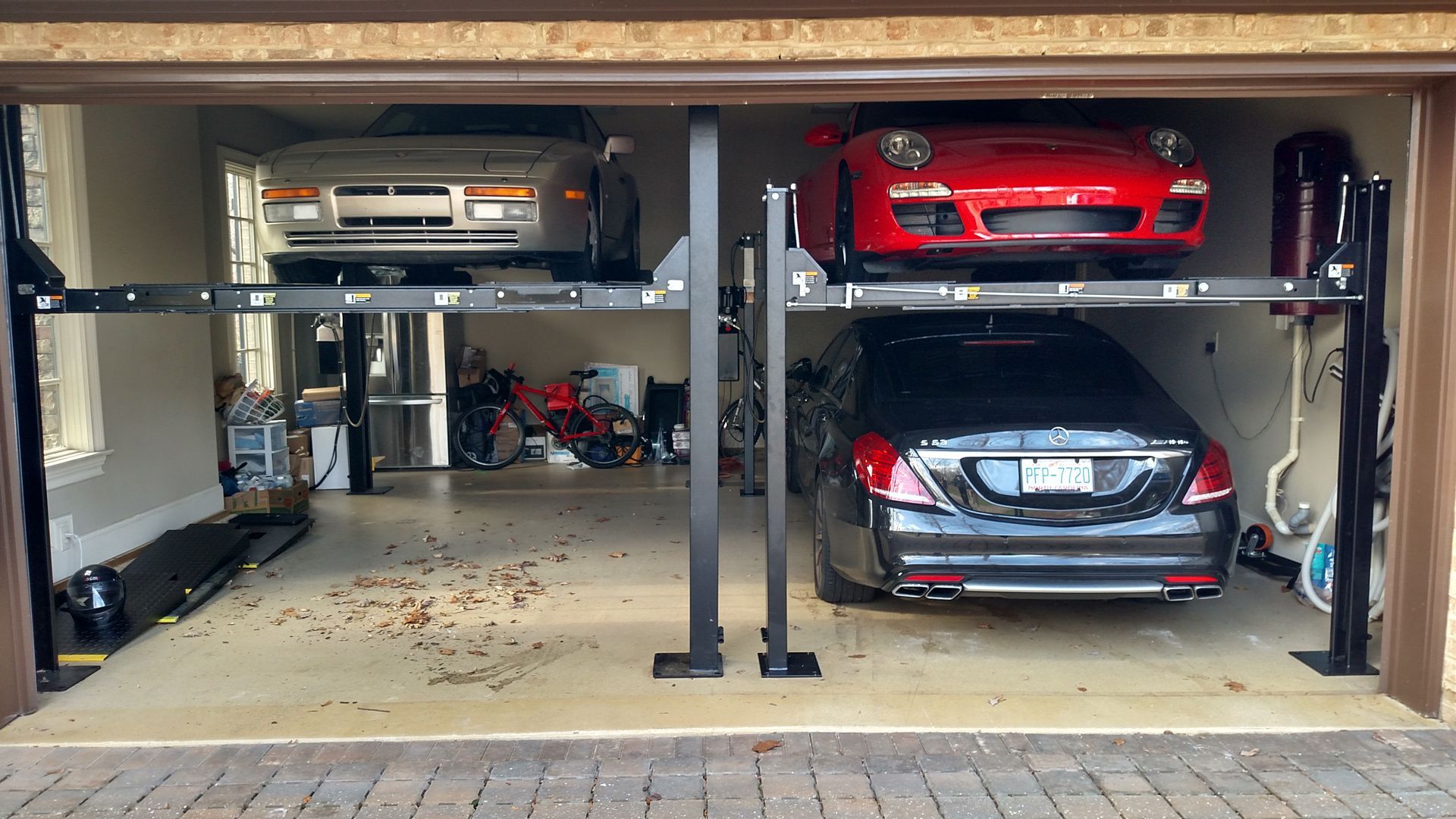 two cars are parked in a garage on a lift