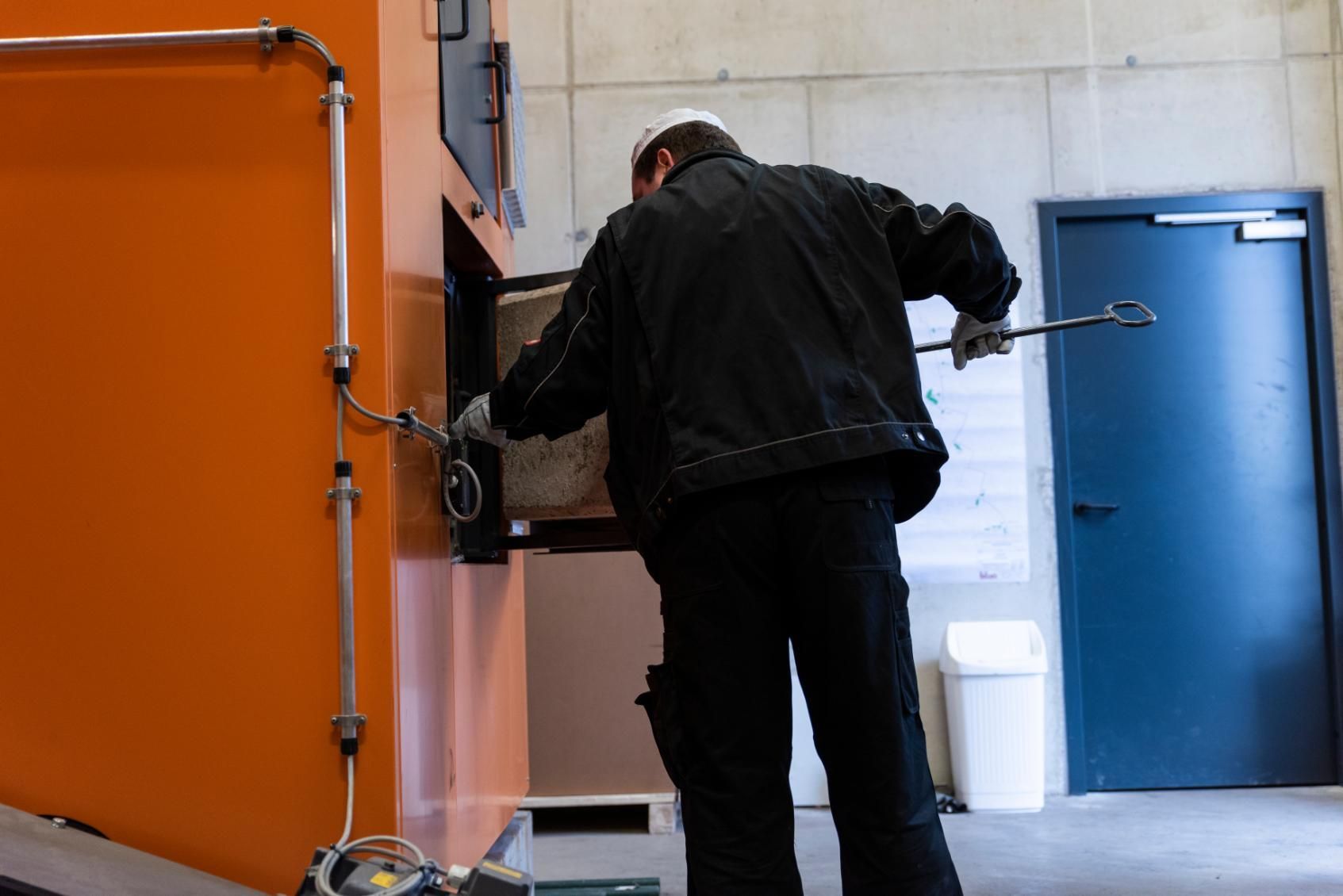 A man is working on a machine with a wrench.