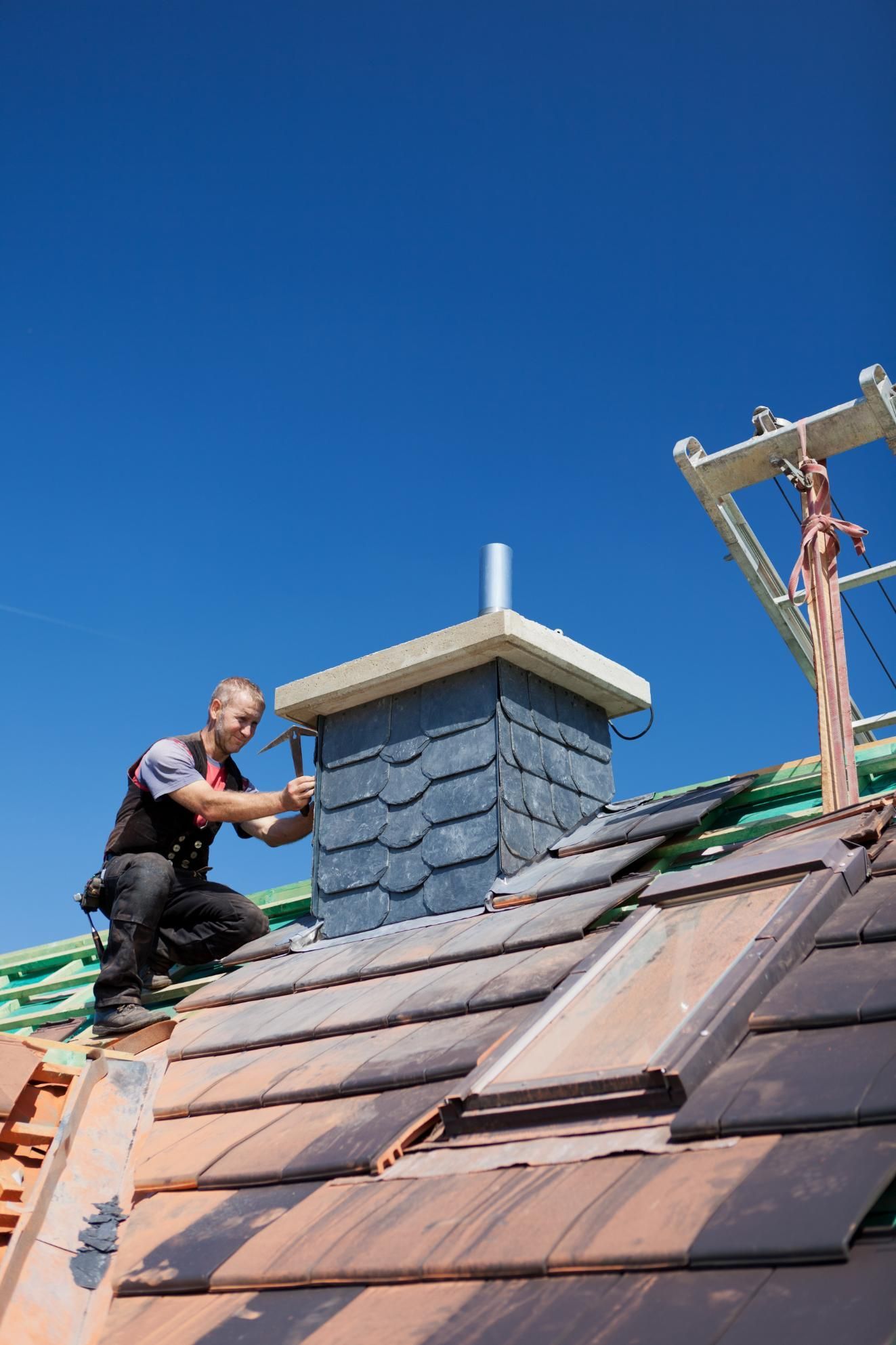 A man is working on the roof of a building.