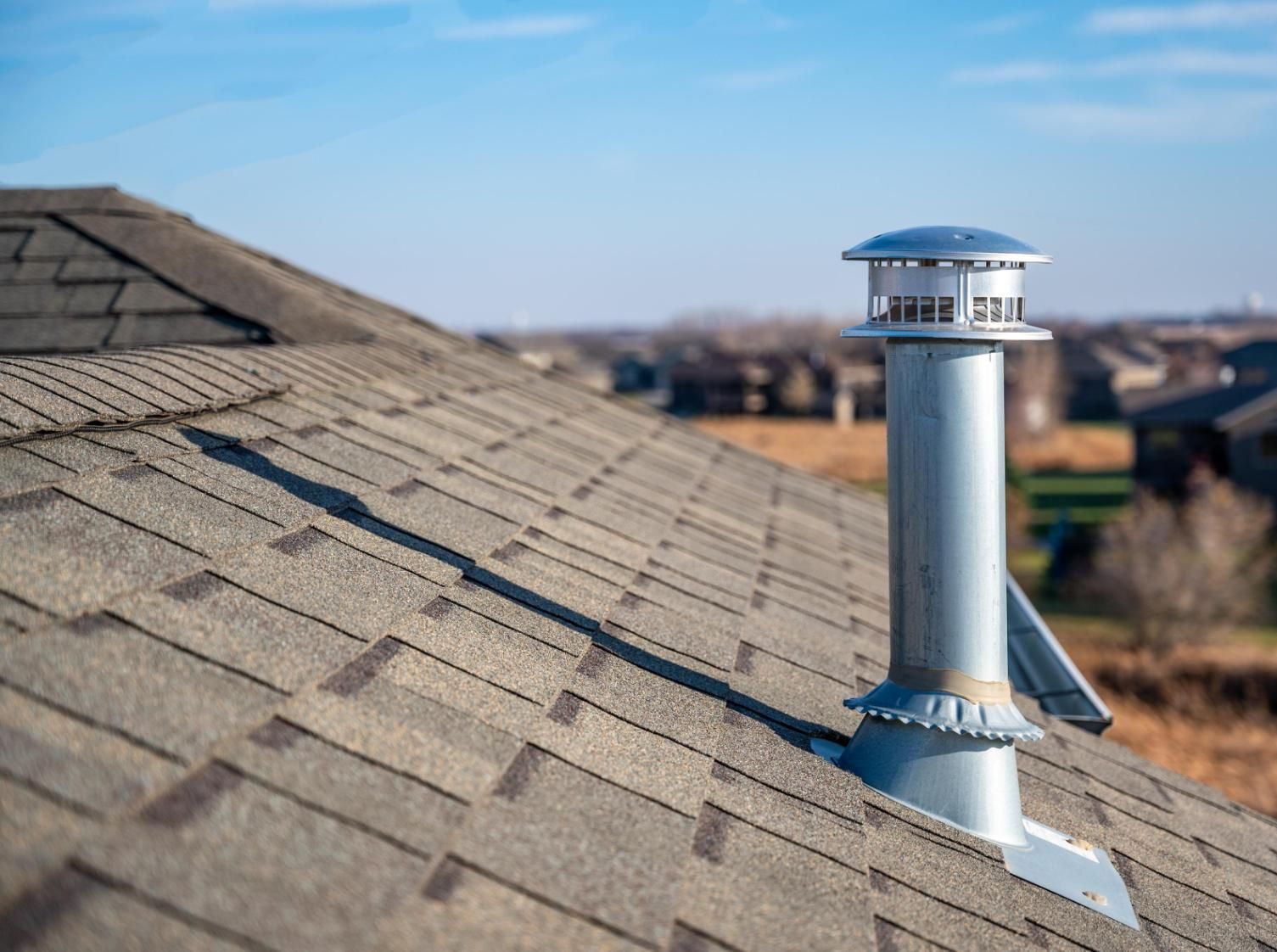 There is a chimney on the roof of a house.