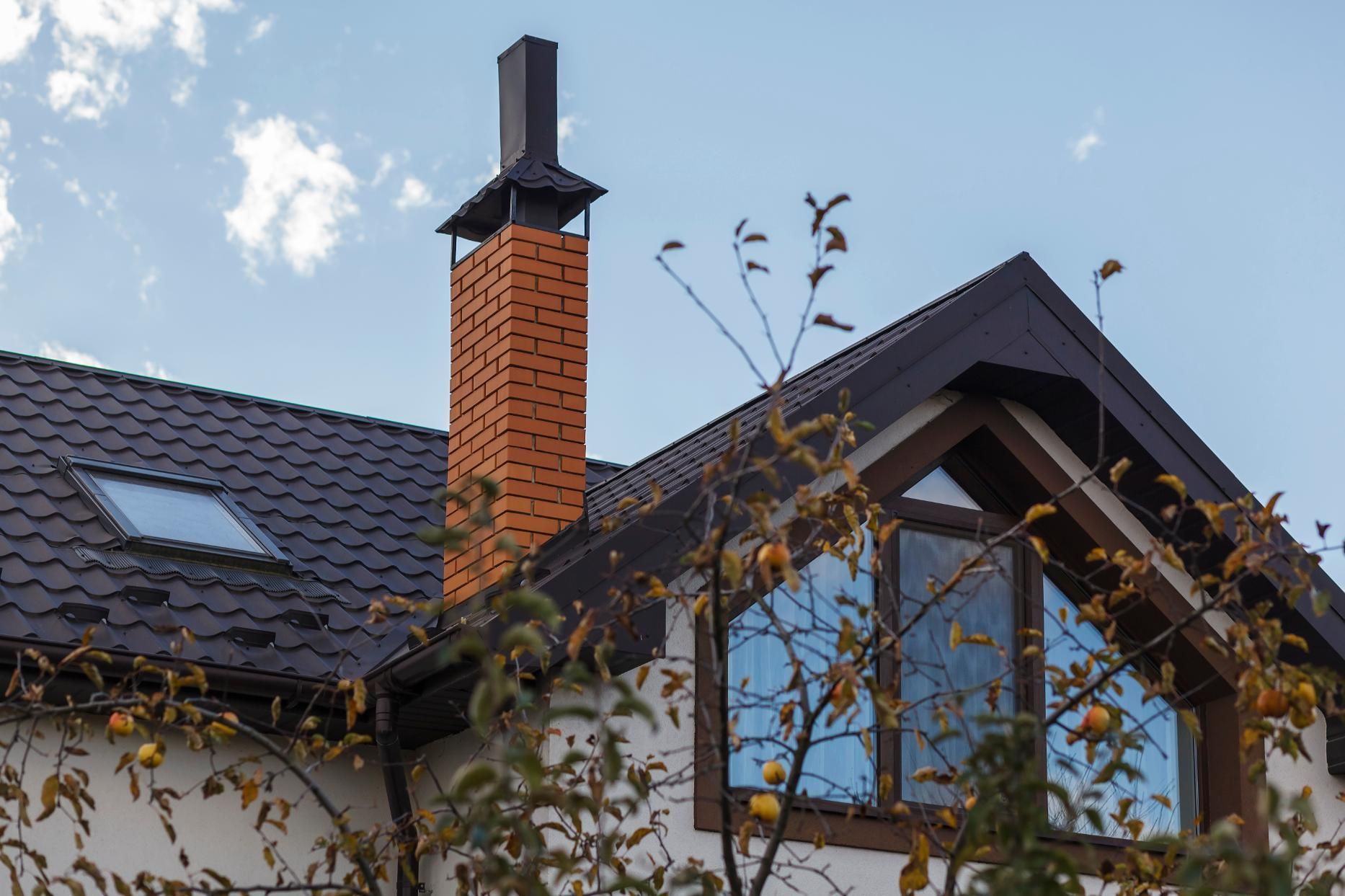 A house with a chimney on the roof and a skylight.