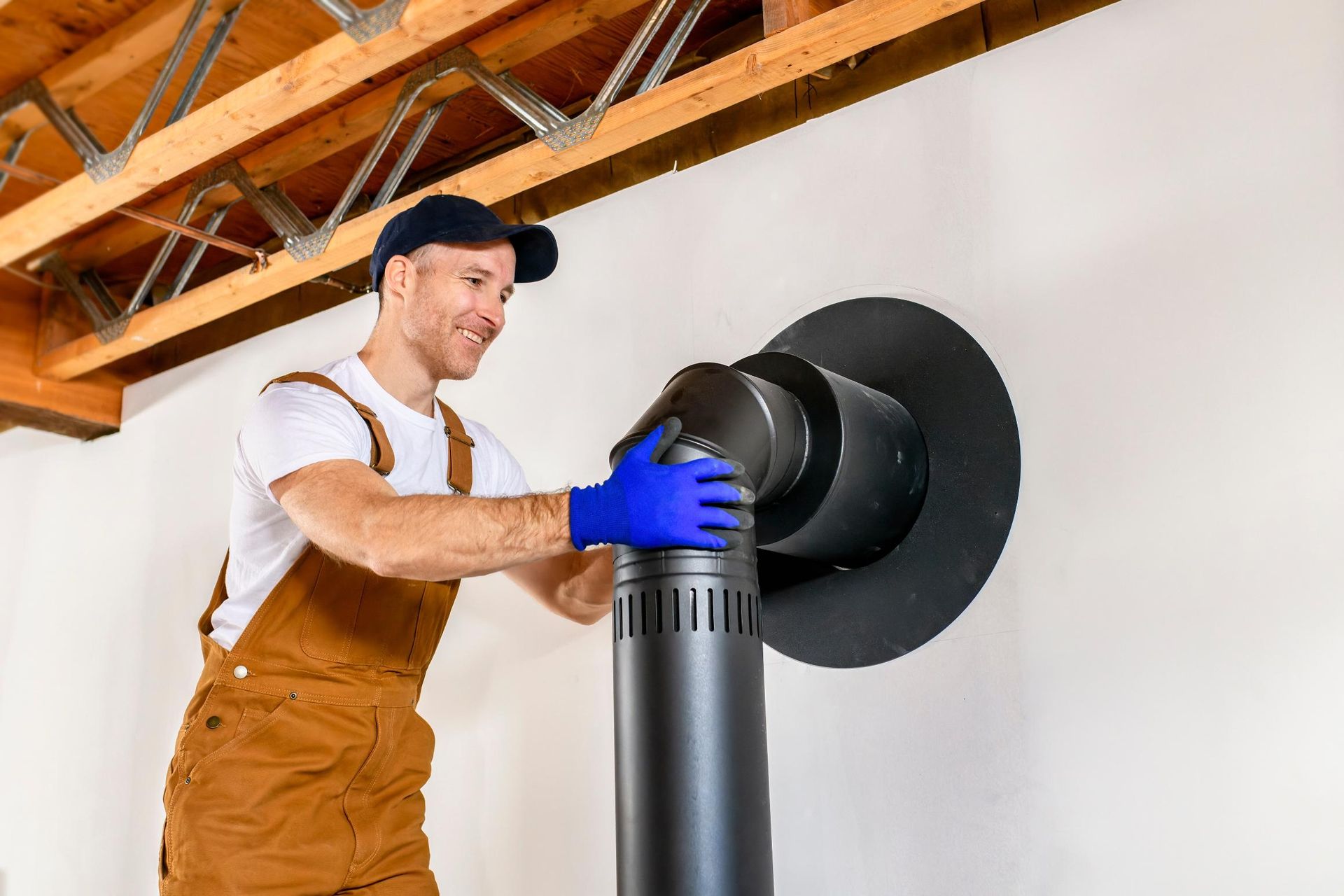 A man is installing a chimney in a house.