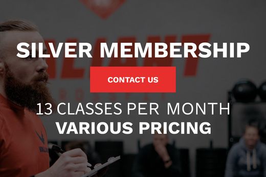 A man with a beard is holding a clipboard in front of a sign that says silver membership