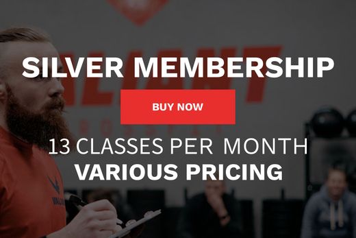A man with a beard is holding a clipboard in front of a sign that says silver membership