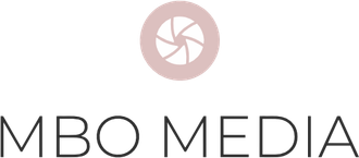 A pink circle with camera lens icon in the middle with MBO media in black text