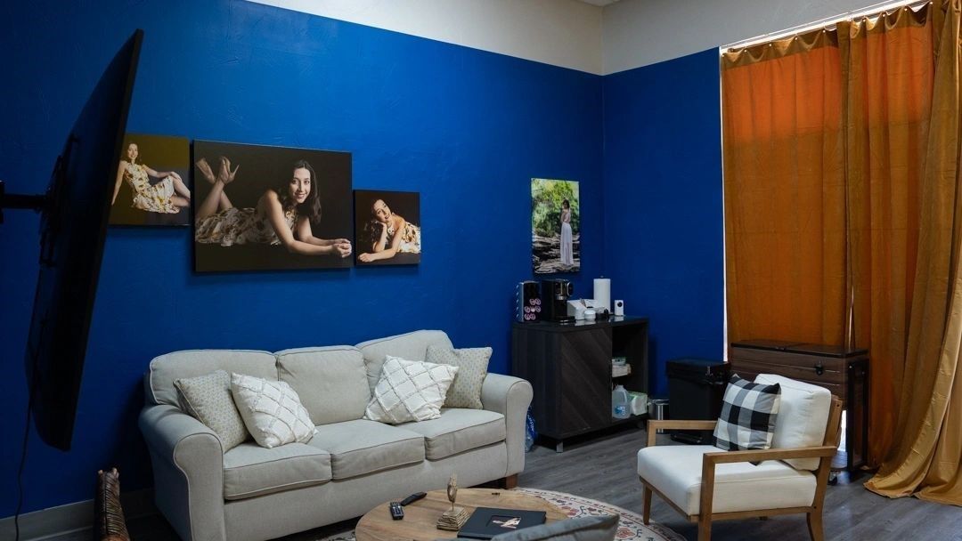 A living room with blue walls and a couch and chair