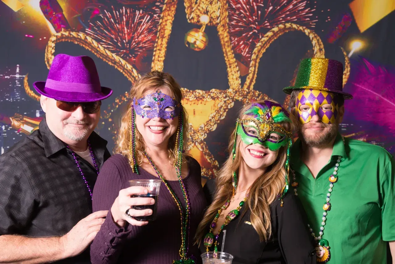 A group of people wearing masks and hats are posing for a picture.