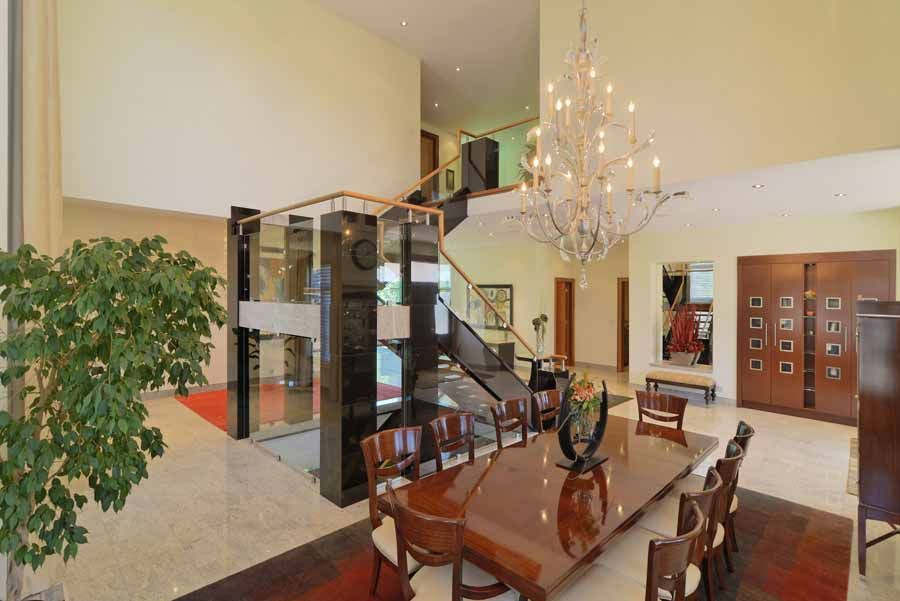 A large dining room with a long table and chairs and a chandelier.