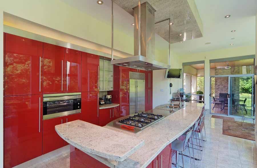 A kitchen with red cabinets and a stove top oven
