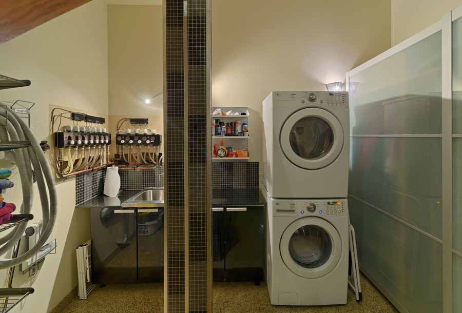 A laundry room with a washer and dryer stacked on top of each other.