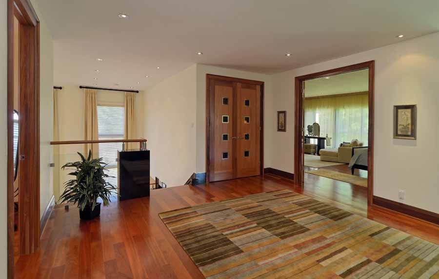 A hallway with hardwood floors and a rug in a house.