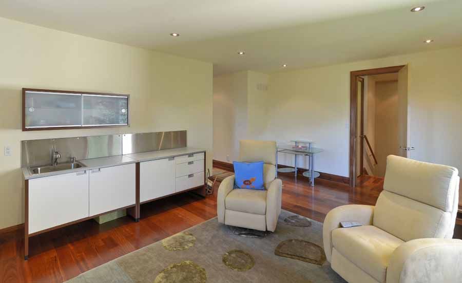 A living room with two chairs and a sink.