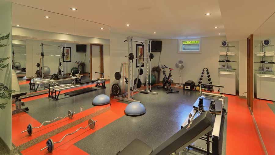 A large gym with a lot of equipment and a lot of mirrors.