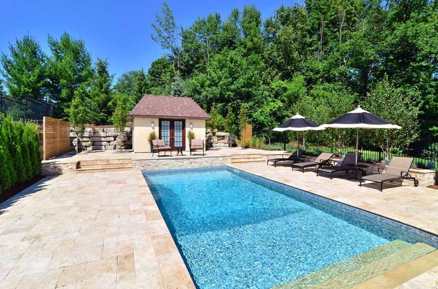 A large swimming pool with umbrellas and chairs around it